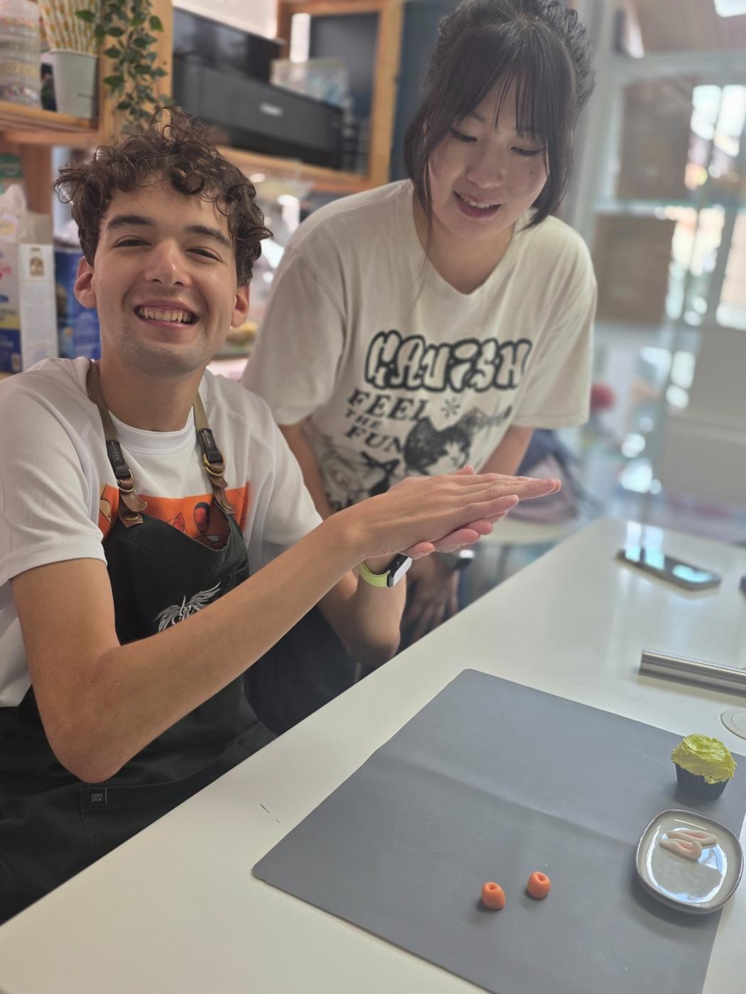 Participant and mentor decorating cupcakes together during a baking workshop