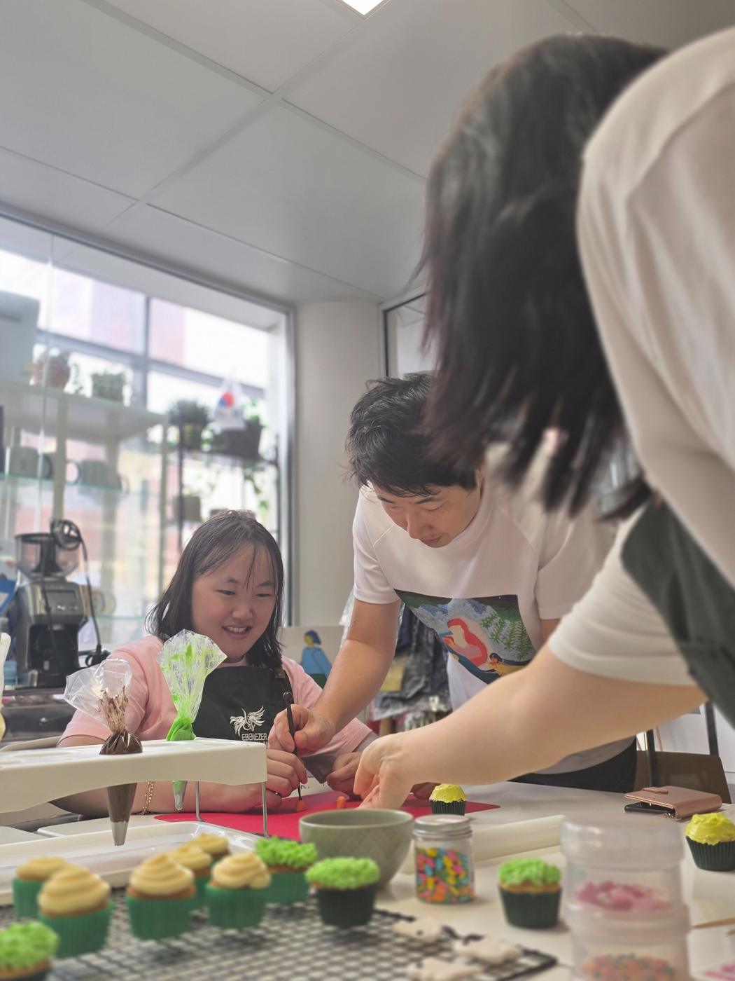 Participant decorating cupcakes in a supported workshop