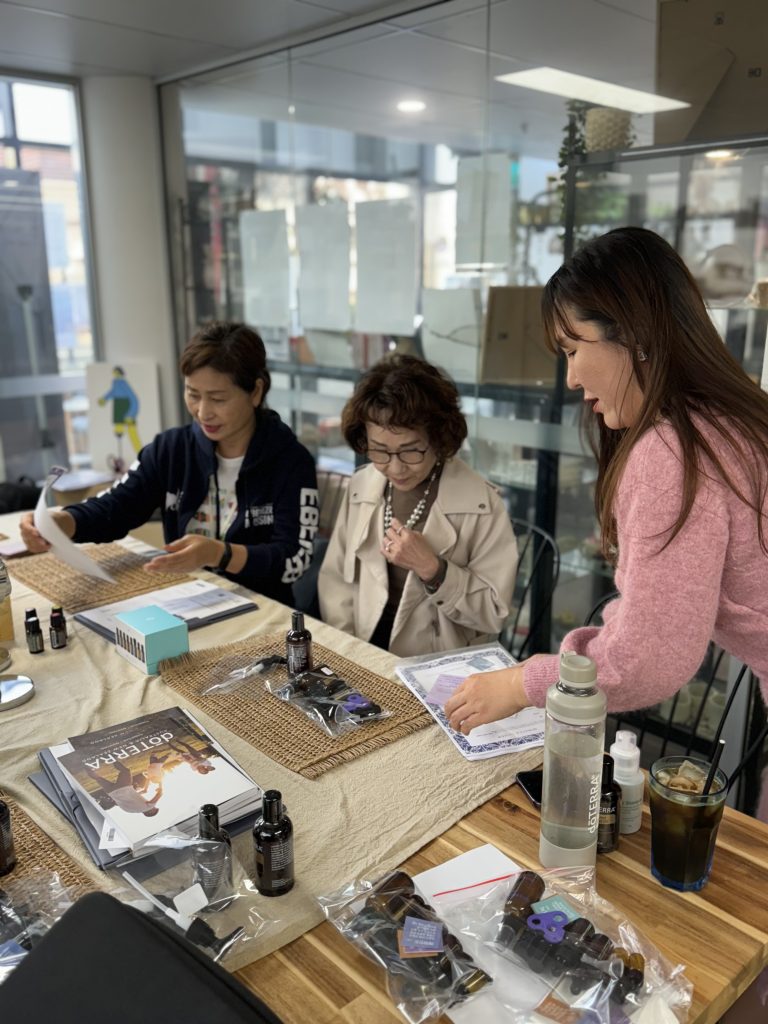 Participants and a facilitator taking part in an aromatherapy activity with essential oils