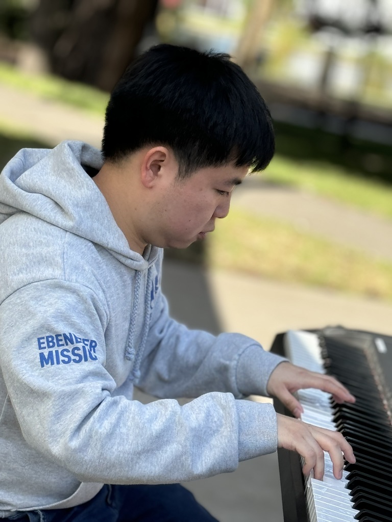 Jonathan Yang playing keyboard outdoors
