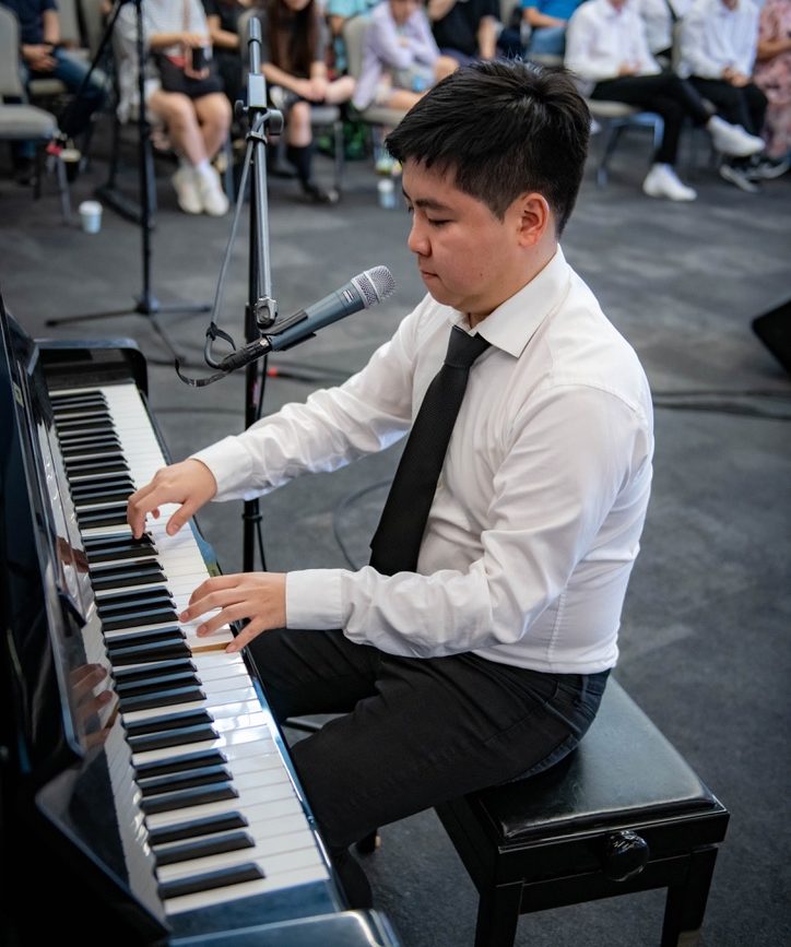 Jonathan Yang performing piano at an Ebenezer Mission community event