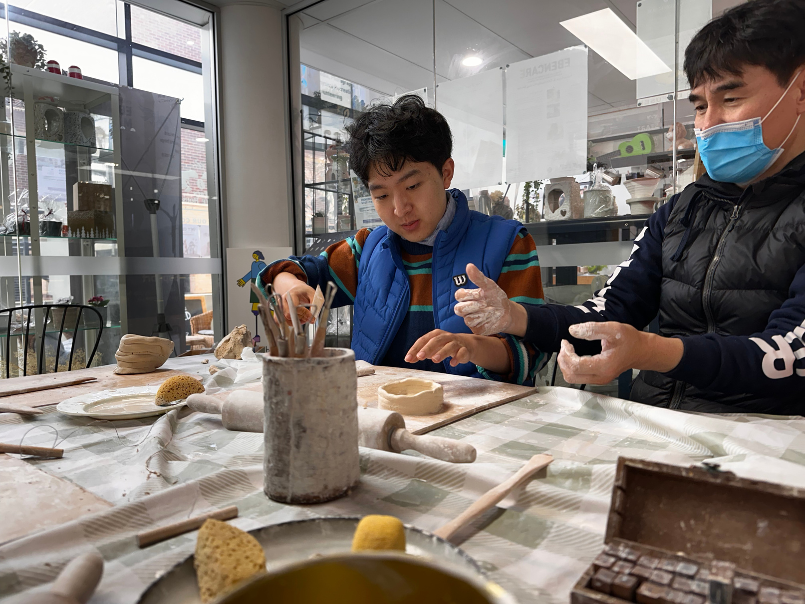 Participants learning pottery skills in a supported workshop